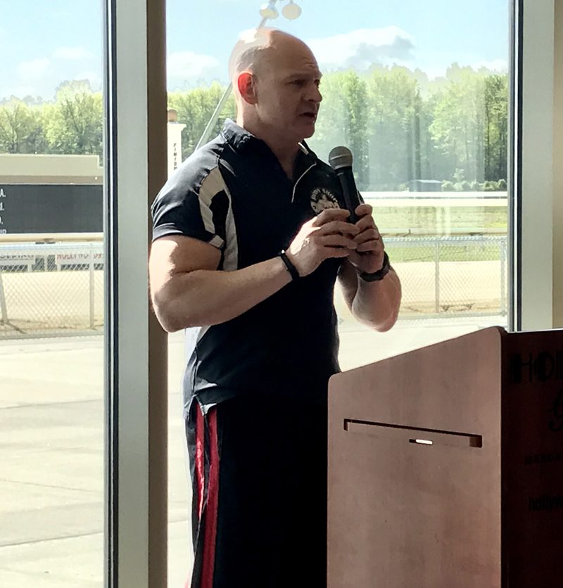 Phil speaking at a podium with a microphone
